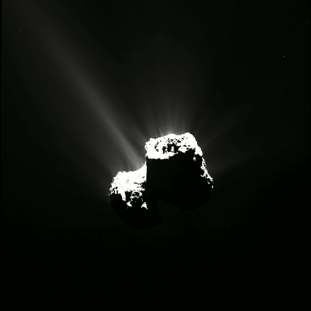 A dark comet with a rough, irregular surface emits bright jets of gas and dust against the blackness of space.